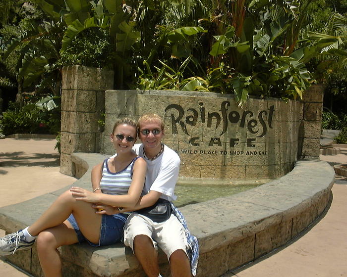 Glenn & Christina next to Rainforest Cafe sign