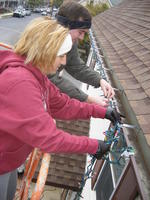 Mike & Heather putting lights on the gutters.