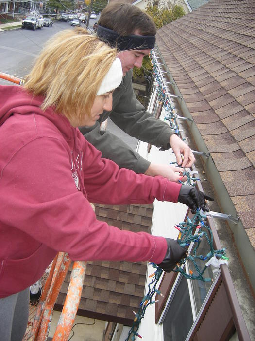 Mike & Heather putting lights on the gutters.