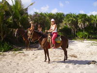 Heather horseback riding on the beach.